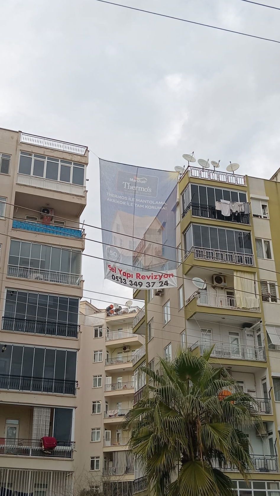 Mantolama yapılan binada Sel Yapı Revizyon afişi